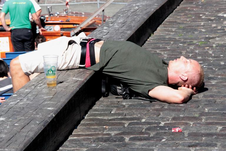 Spiaci človek na verejnosti, opilec, poháre od piva